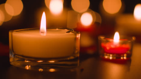 Nahaufnahme-Romantisch-Angezündeter-Roter-Und-Weißer-Kerzen,-Die-Auf-Schwarzem-Hintergrund-Mit-Bokeh-Beleuchtung-Brennen-1